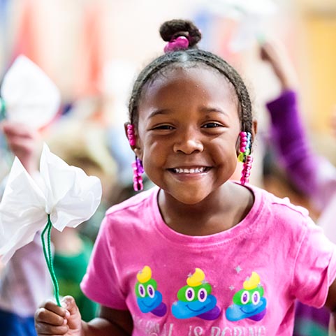  girl with pink shirt smiling at camera